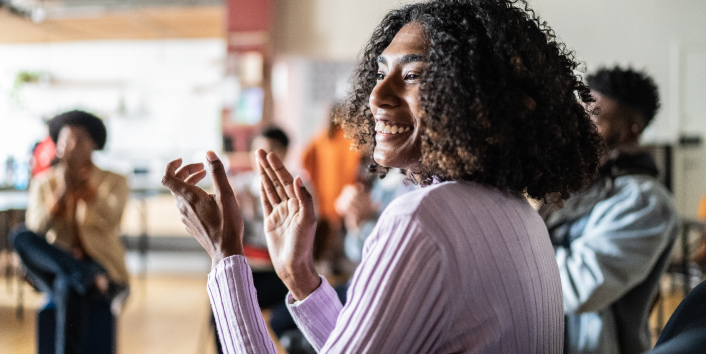 Woman clapping and smiling while at community event